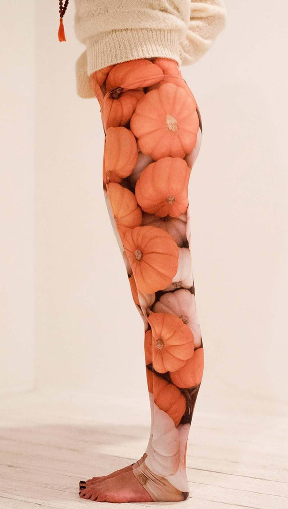 Left side view of model wearing white and orange pumpkin leggings