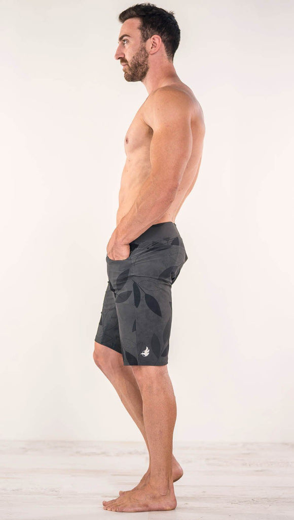 Left side view of model wearing gray printed performance shorts with slim fit and vilva leaf inspired art