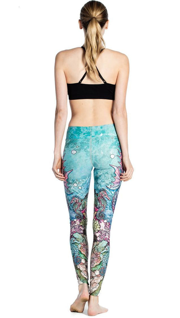back view of model wearing colorful seahorse themed printed full length leggings