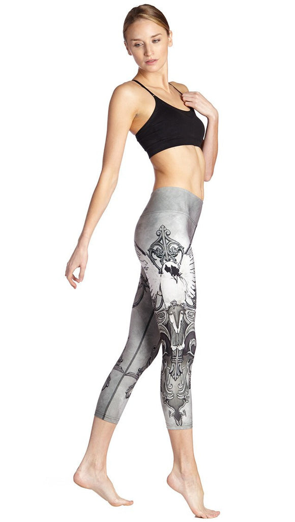 right side view of model wearing black and white fantasy dove themed printed capri leggings