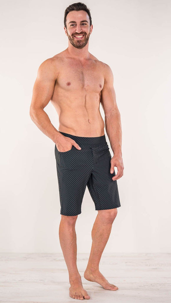 Front view of model wearing men's black printed performance shorts with slim fit and carbon fiber inspired art.