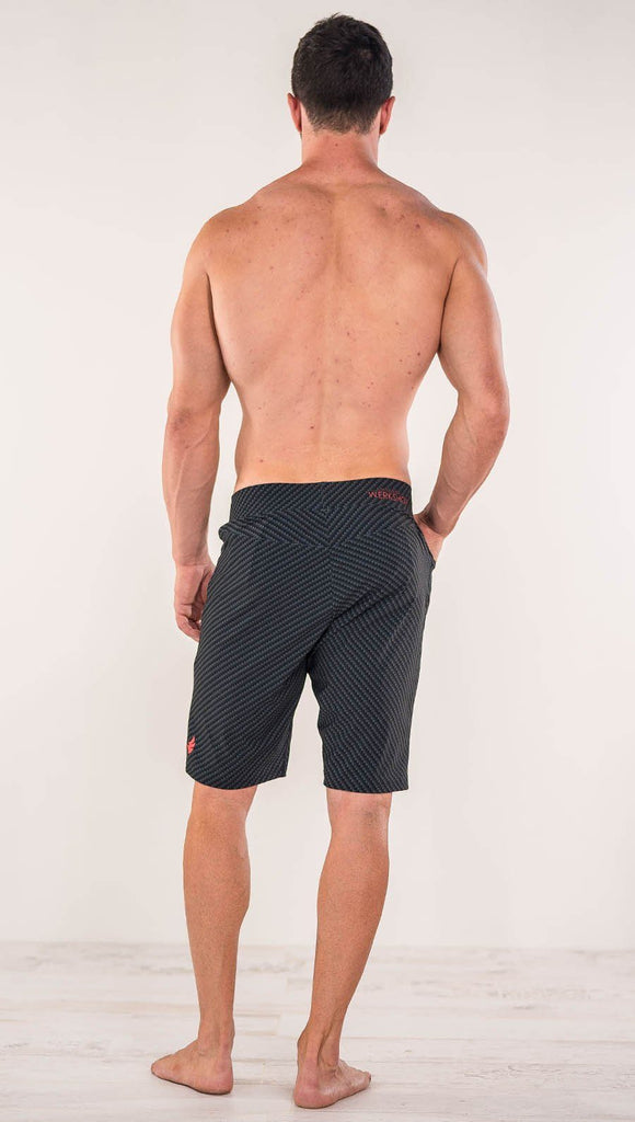 Back view of model wearing men's black printed performance shorts with slim fit and carbon fiber inspired art.