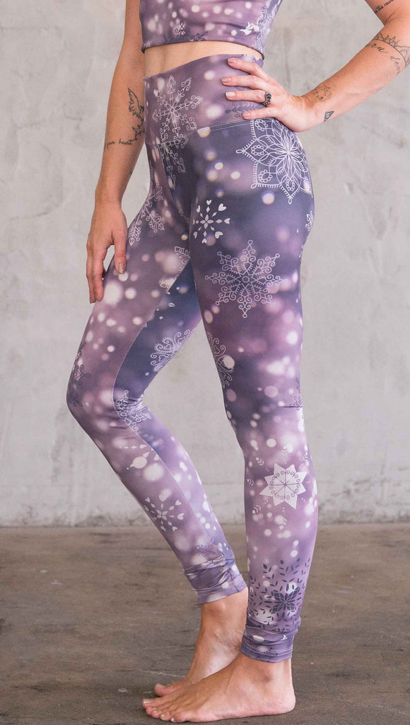 Enhanced left view of model wearing purple leggings with white snowflakes