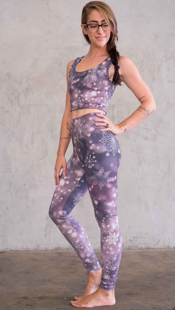 Left view of model wearing purple leggings with white snowflakes