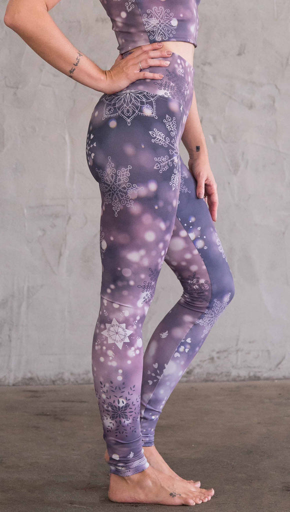 Enhanced right view of model wearing purple leggings with white snowflakes