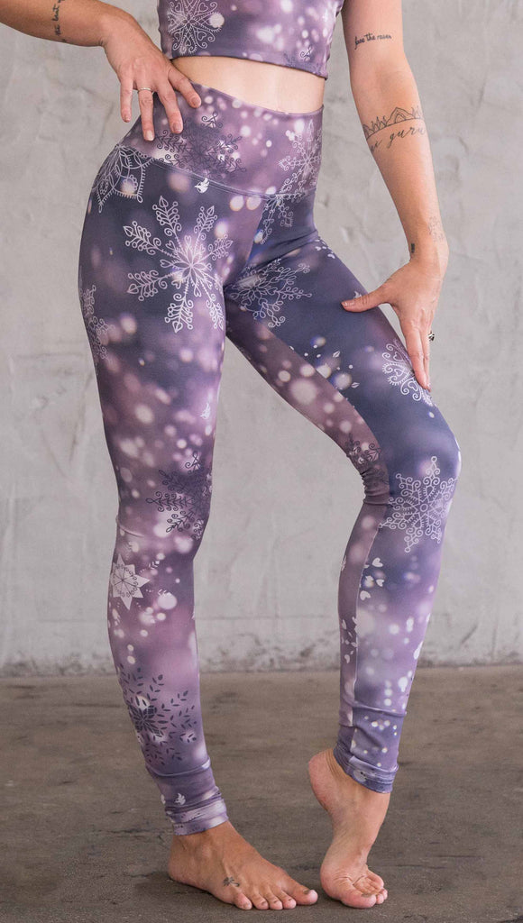 Front right view of model wearing purple leggings with white snowflakes