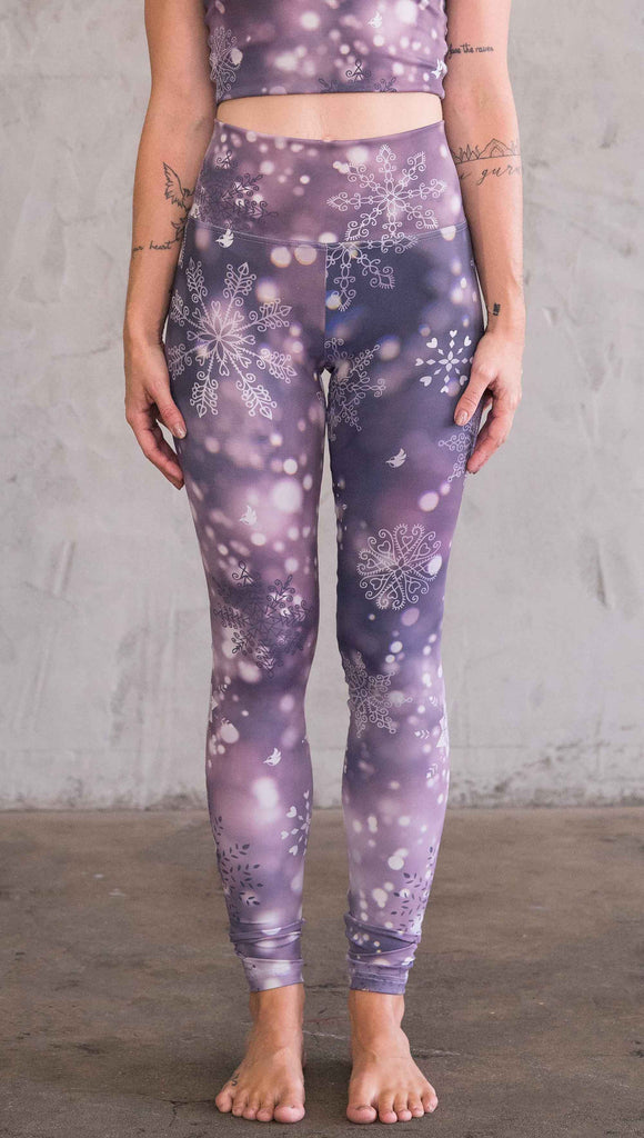 Enhanced front view of model purple leggings with white snowflakes