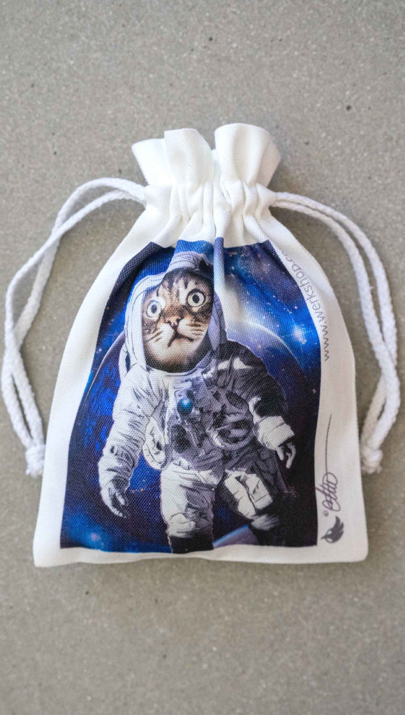 WERKSHOP Space Cat (Catstronaut) canvas drawstring pouch (comes free with matching puzzle)! The artwork features a house cat wearing an astronaut uniform, floating in outer space with a nebula behind him.