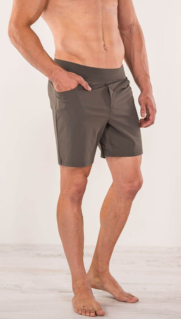 Close up right side view of model wearing men's taupe performance shorts with slim fit