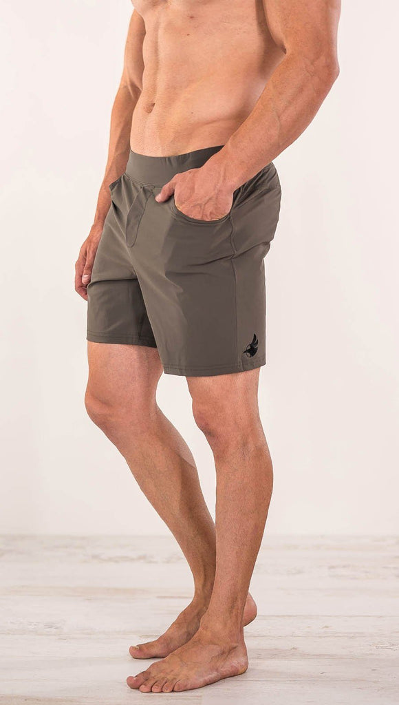 Close up left side view of model wearing men's taupe performance shorts with slim fit