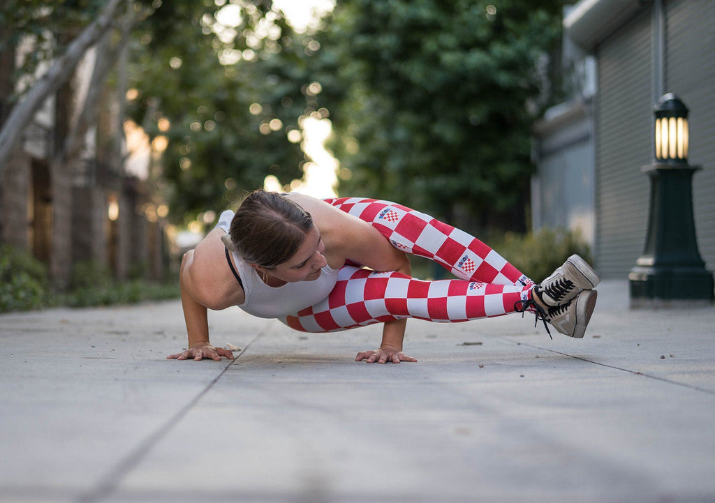 view of model in yoga pose wearing croatian checkered themed full length leggings