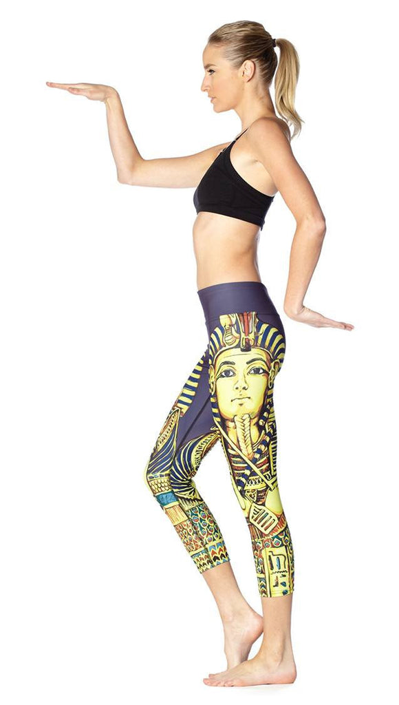 left side view of model wearing King Tut themed printed capri leggings