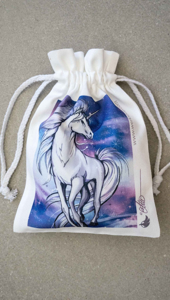 Canvas Drawstring WERKSHOP Unicorn Pouch - comes free with matching 252 piece jigsaw puzzle. The puzzle is printed with original artwork of a Unicorn by Chriztina Marie. It features a white unicorn prancing on a fantastical galactic background with swirls of purple and blue with sparkles. 